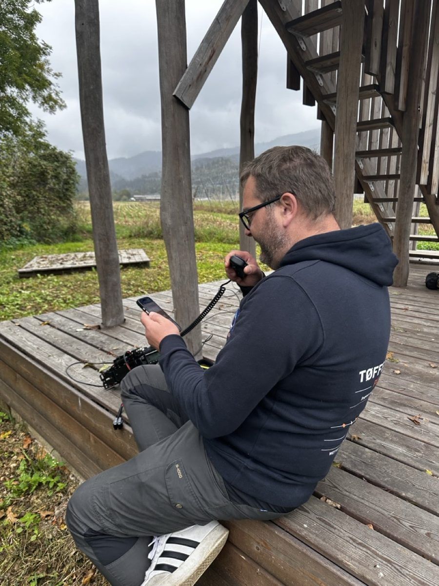 Betrieb auf der Holzplattform, Mikro in der einen, Handy-Log in der anderen Hand
